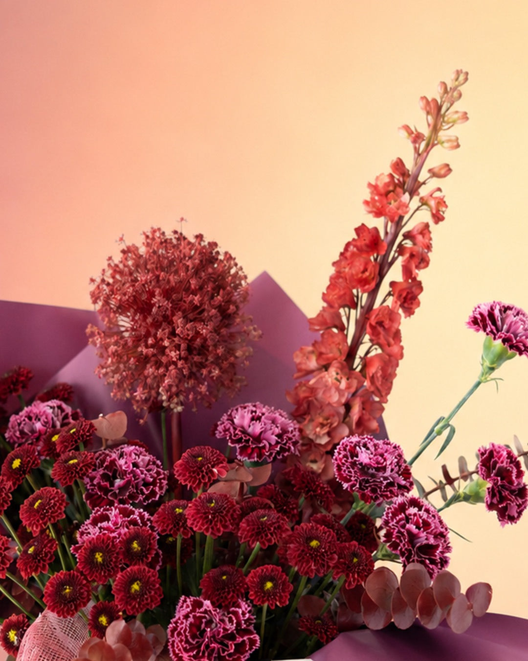 Maroon Melody flower bag arrangement with deep burgundy blooms in a stylish carry bag from Whimsy Flowers Abu Dhabi.