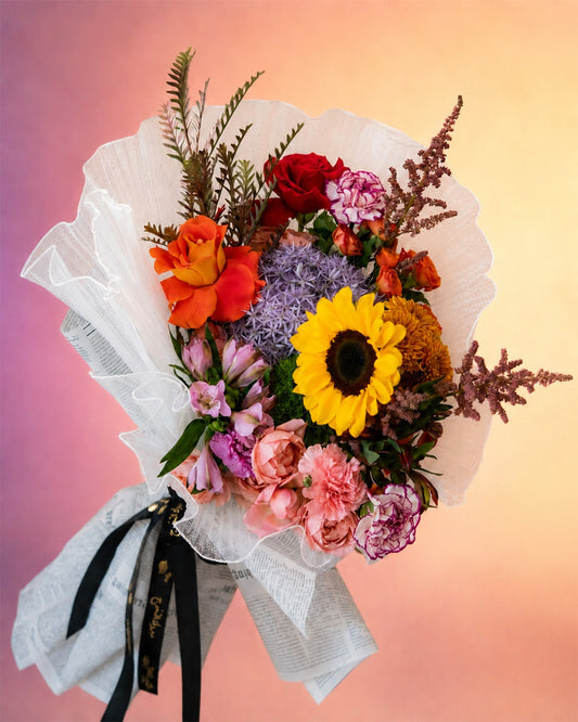Floral Rhapsody flower bouquet with sunflowers and vibrant mixed blooms from Whimsy Flowers Abu Dhabi.