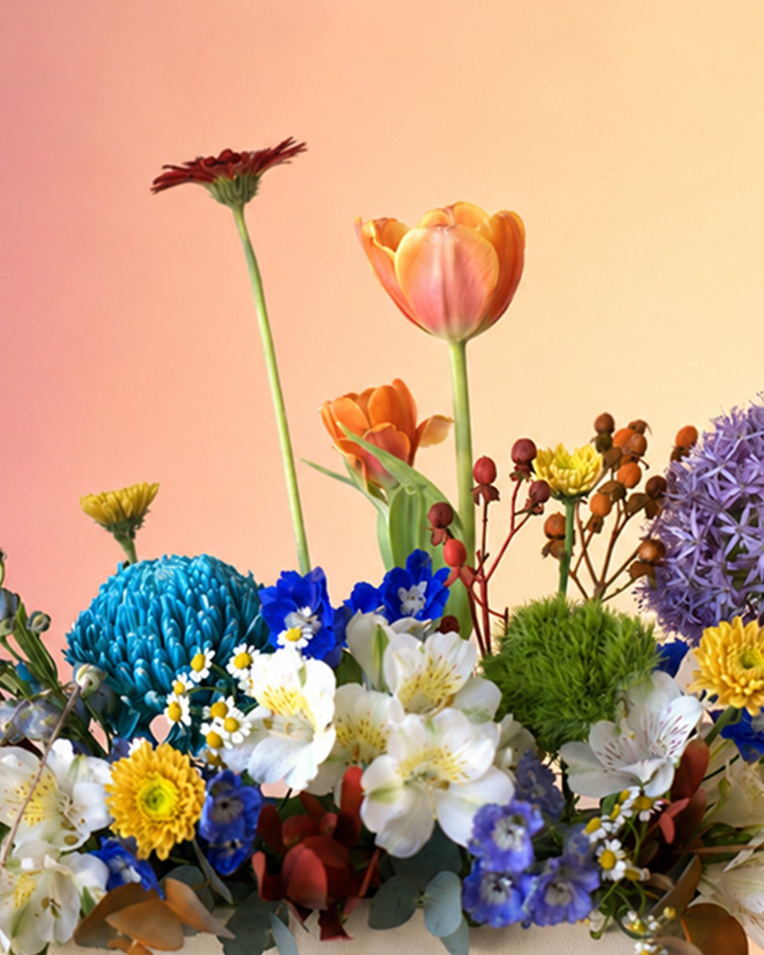 Spring Kaleidoscope flower vase arrangement with vibrant mixed spring blooms in a white vase from Whimsy Flowers Abu Dhabi.
