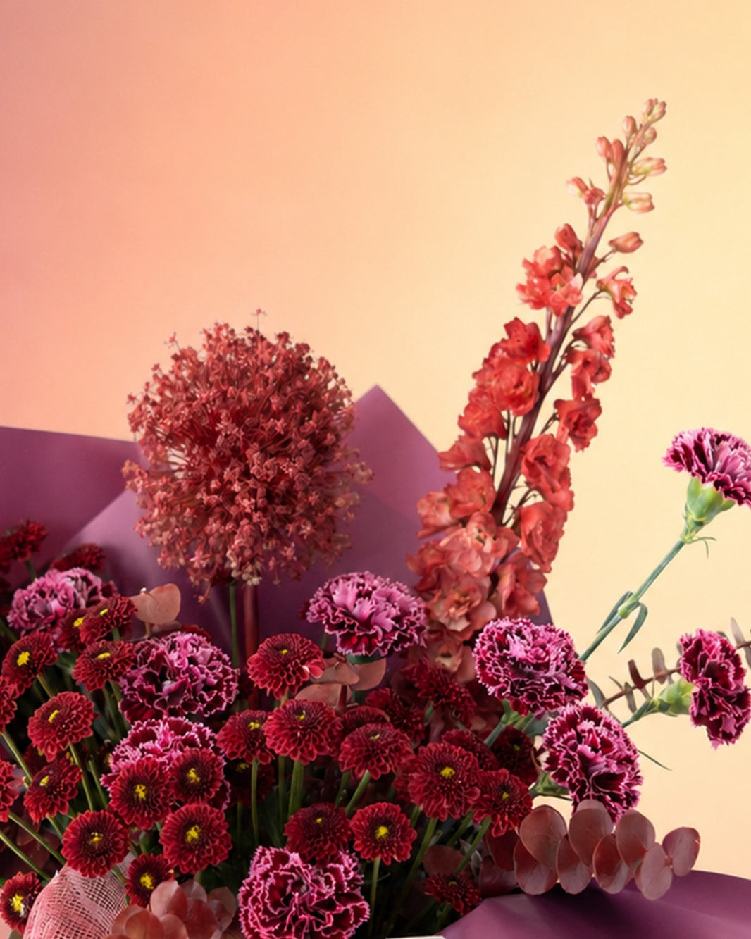 Maroon Melody flower bag arrangement with deep burgundy blooms in a stylish carry bag from Whimsy Flowers Abu Dhabi.