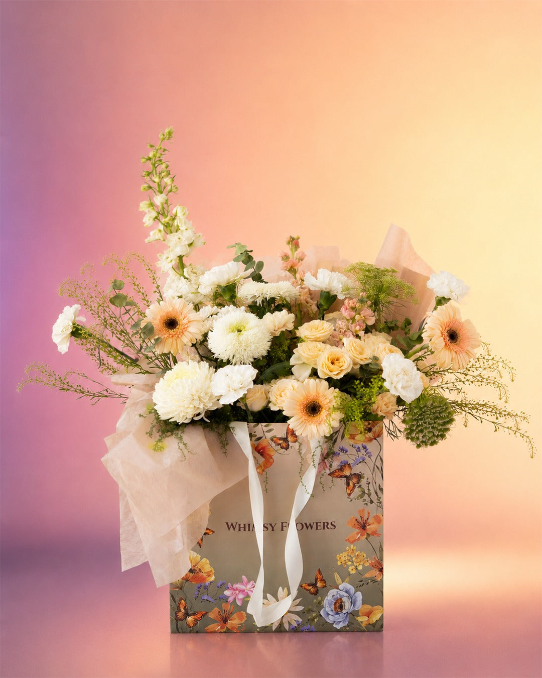 Peach Poise flower bag arrangement with soft peach and cream blooms in a stylish carry bag from Whimsy Flowers Abu Dhabi.