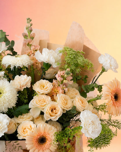 Peach Poise flower bag arrangement with soft peach and cream blooms in a stylish carry bag from Whimsy Flowers Abu Dhabi.