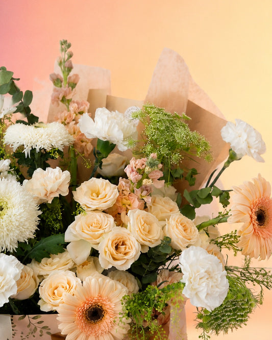 Peach Poise flower bag arrangement with soft peach and cream blooms in a stylish carry bag from Whimsy Flowers Abu Dhabi.