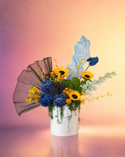 Blue Eclipse flower box with sunflowers, blue delphinium and mixed blooms in an elegant box from Whimsy Flowers Abu Dhabi.