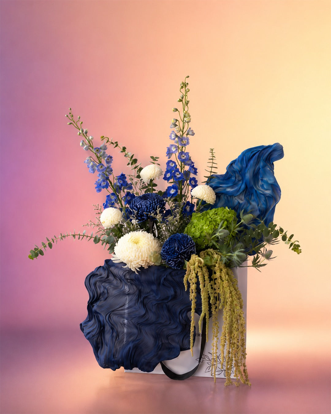 Celestial Blue flower bag arrangement with deep blue and dried florals in a stylish carry bag from Whimsy Flowers Abu Dhabi.