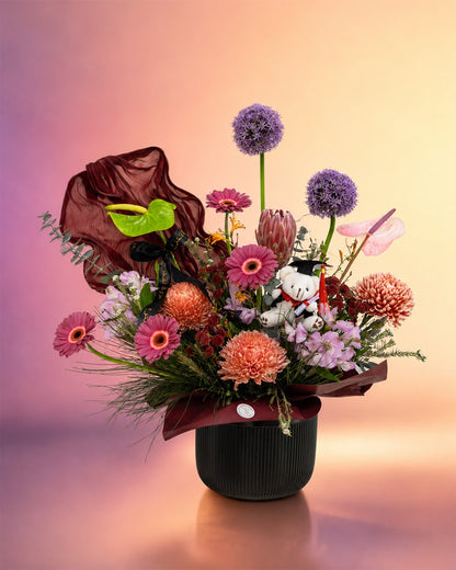 Graduation Garden Luxe flower arrangement with luxe mixed blooms in a black vase from Whimsy Flowers Abu Dhabi.