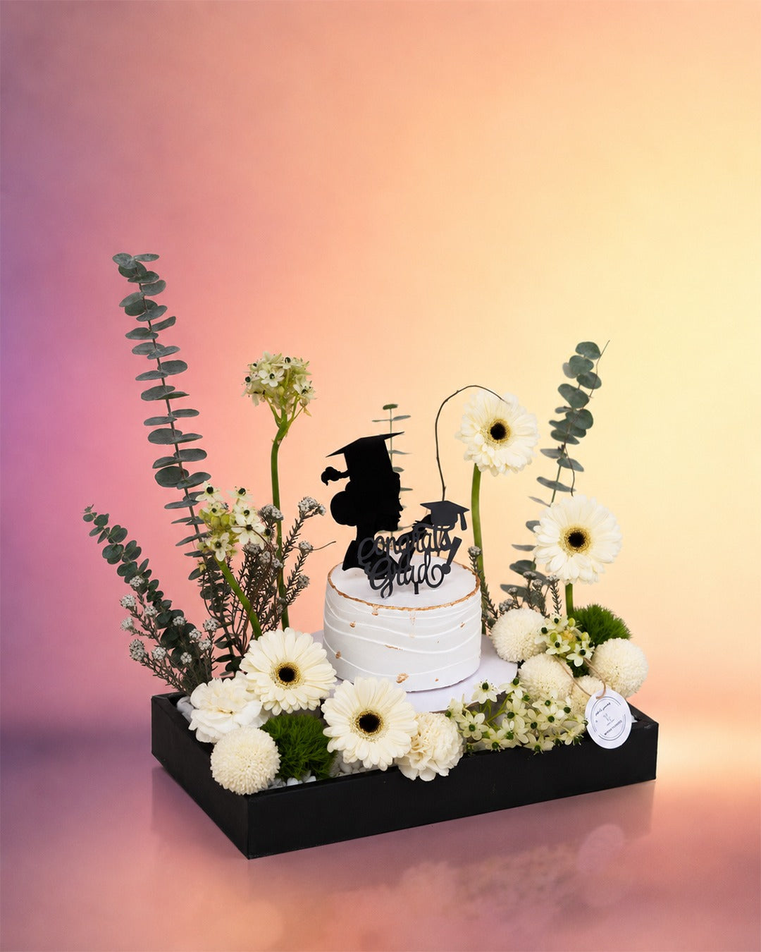 Graduation Grace cake box with flowers and celebration cake from Whimsy Flowers Abu Dhabi.