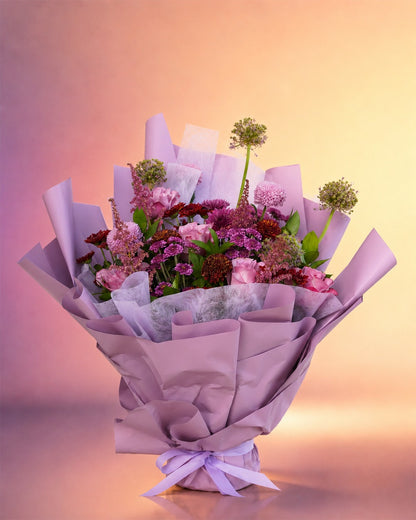 Lilac Dream flower bouquet with lilac and pink florals in soft purple wrap from Whimsy Flowers Abu Dhabi.