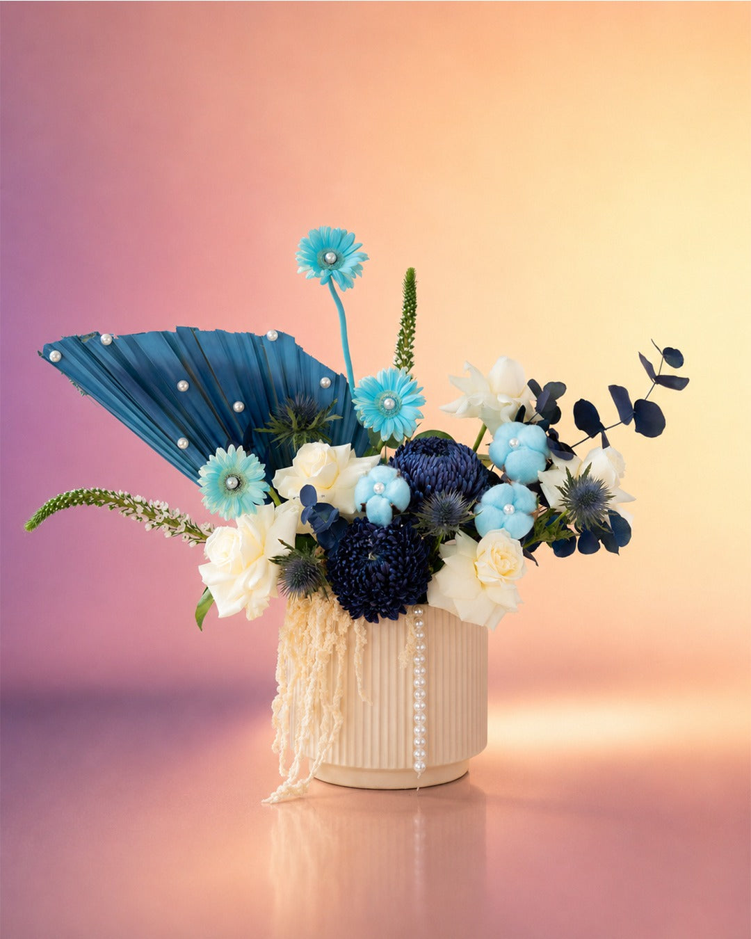 Pearls and Petals new born baby flower arrangement with blue blooms in a woven vase from Whimsy Flowers Abu Dhabi.