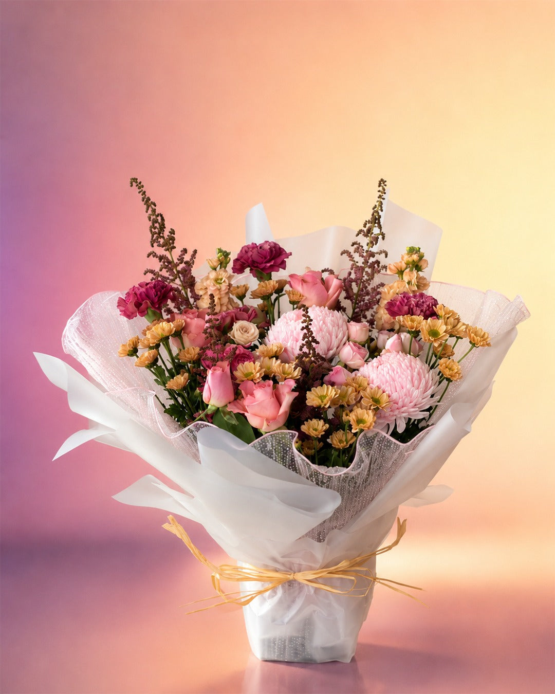 Petals and Poetry flower bouquet with pink and burgundy blooms wrapped in soft paper from Whimsy Flowers Abu Dhabi.