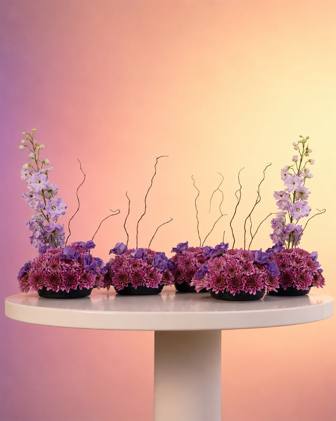 Purple Poetry flower centerpiece with dreamy purple blooms and willow in a moss base from Whimsy Flowers Abu Dhabi.