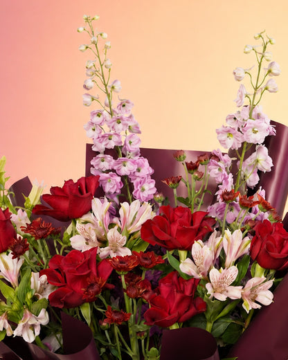 Red Velvet Serenade flower bouquet with rich red roses in an elegant wrap from Whimsy Flowers Abu Dhabi.