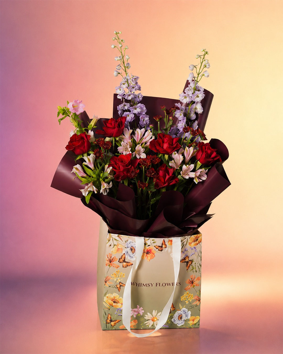 Red Velvet Serenade flower bouquet with rich red roses in an elegant wrap from Whimsy Flowers Abu Dhabi.