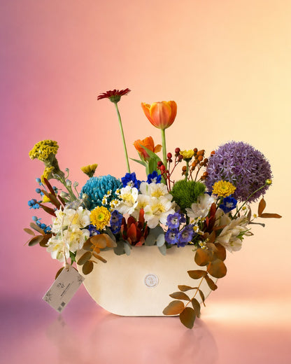 Spring Kaleidoscope flower vase arrangement with vibrant mixed spring blooms in a white vase from Whimsy Flowers Abu Dhabi.